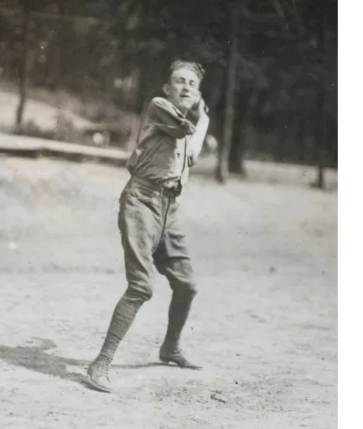 Amputee baseball player throwing a ball.